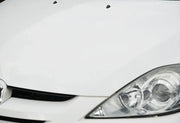 White car front bumper and headlight showing glossy waxed finish
