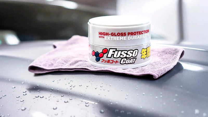Fusso Coat wax tin on car hood with microfiber cloth
