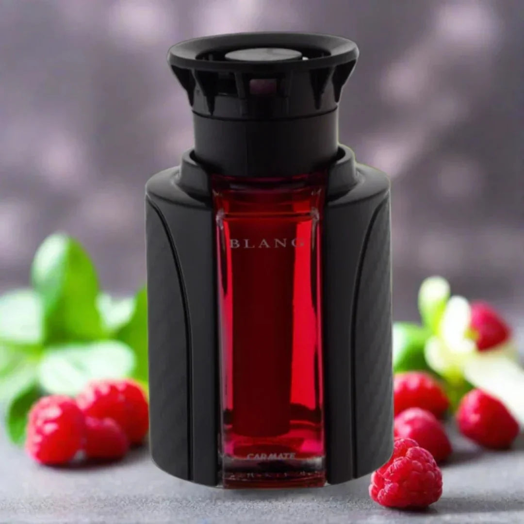 Red BLANG car air freshener with black holder, surrounded by raspberries and green leaves