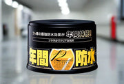 Soft99 Fusso Coat 12 Months Wax tin for dark cars on reflective floor
